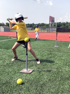 girl at softball camp batting practice
